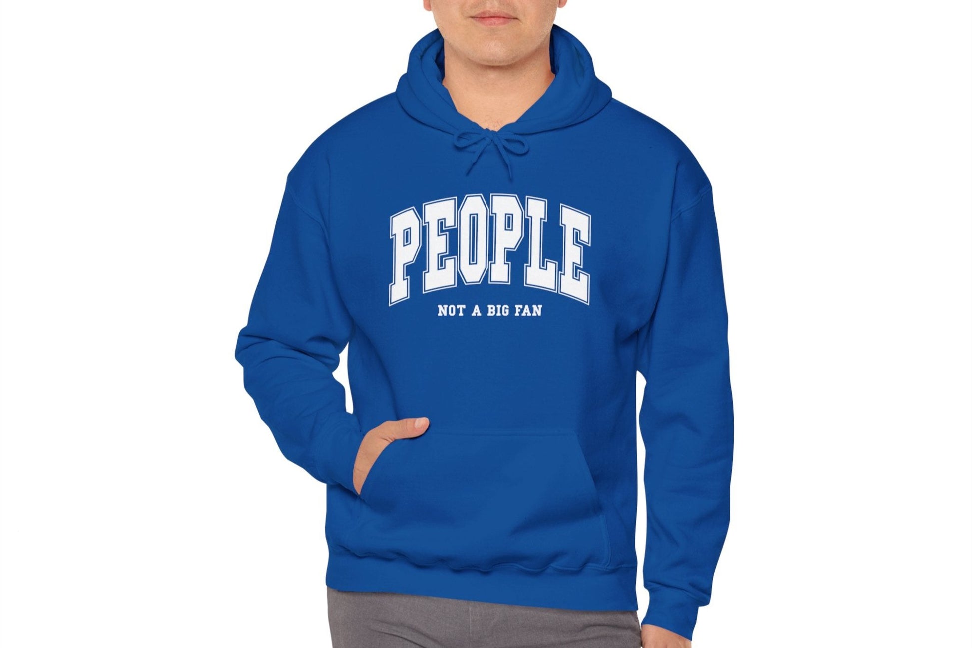 Model wearing a blue hoodie featuring the text "People, Not a Big Fan" in bold collegiate-style white lettering. Part of the Vivid Divergence Sensory Friendly Unisex Hoodie Range.