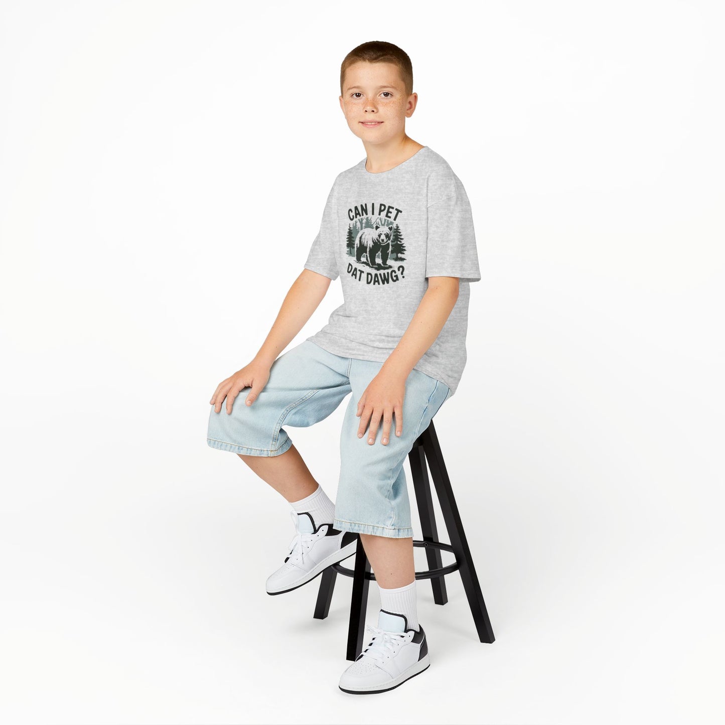 Boy sitting on a stool wearing a gray "Can I Pet Dat Dawg" meme kids T-shirt with a playful dog graphic. Part of the Vivid Divergence Sensory Friendly Kids Shirts Range. The perfect T-shirt for sensory-sensitive kids and comes with a Sensory Satisfaction Promise.