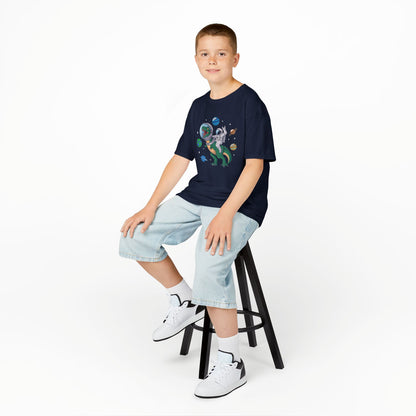 Boy sitting on a stool wearing a navy blue "Jurassic Space Jam" kids T-shirt with a dinosaur and astronaut floating among planets. Part of the Vivid Divergence Sensory Friendly Kids Shirts Range. The perfect T-shirt for sensory-sensitive kids and comes with a Sensory Satisfaction Promise.