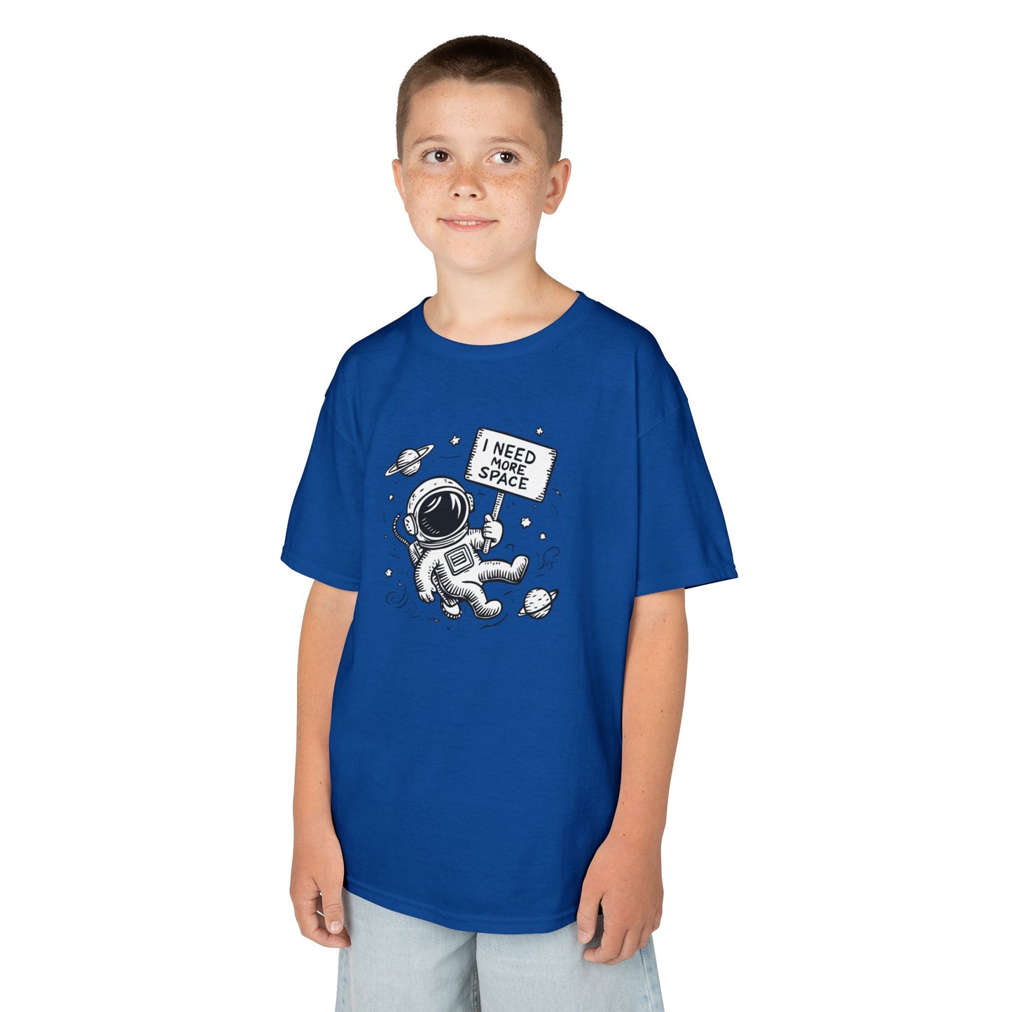 Boy wearing a royal blue "I Need More Space" astronaut kids T-shirt with a cartoon astronaut floating among space icons. Part of the Vivid Divergence Sensory Friendly Kids Shirts Range. The perfect T-shirt for sensory-sensitive kids and comes with a Sensory Satisfaction Promise.