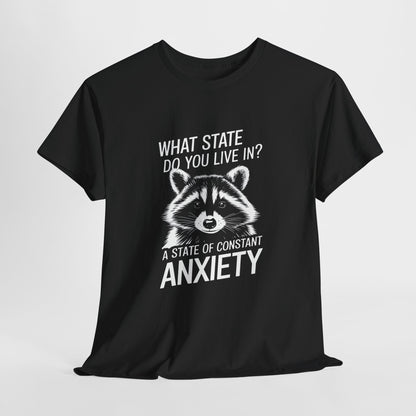 Hanging black T-shirt with a white raccoon graphic and the text "What state do you live in? A constant state of anxiety." Part of the Vivid Divergence Sensory Friendly Unisex Tees Range.