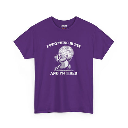 Front view of purple T-shirt featuring a vintage style sketch of a raccoon carrying the world with the phrase “Everything Hurts and I’m Tired.” The official uniform of burnt out. Part of the Vivid Divergence Memewear Collection!