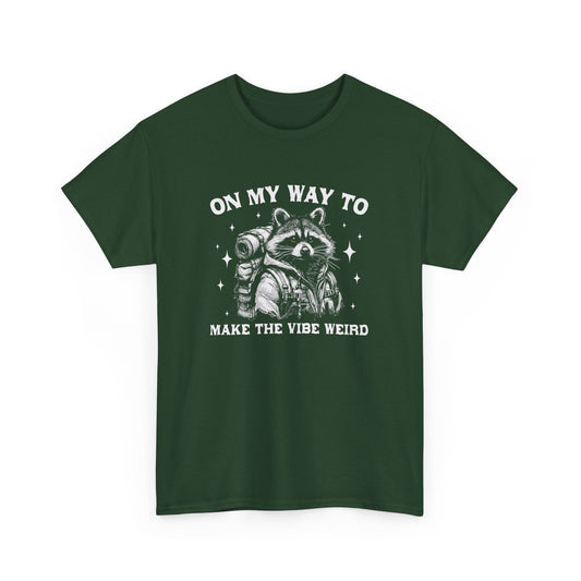 Front view of a forest green T-shirt with "On My Way to Make the Vibe Weird" and a raccoon graphic in white text. Part of the Vivid Divergence Sensory Friendly Unisex Tees Range.
