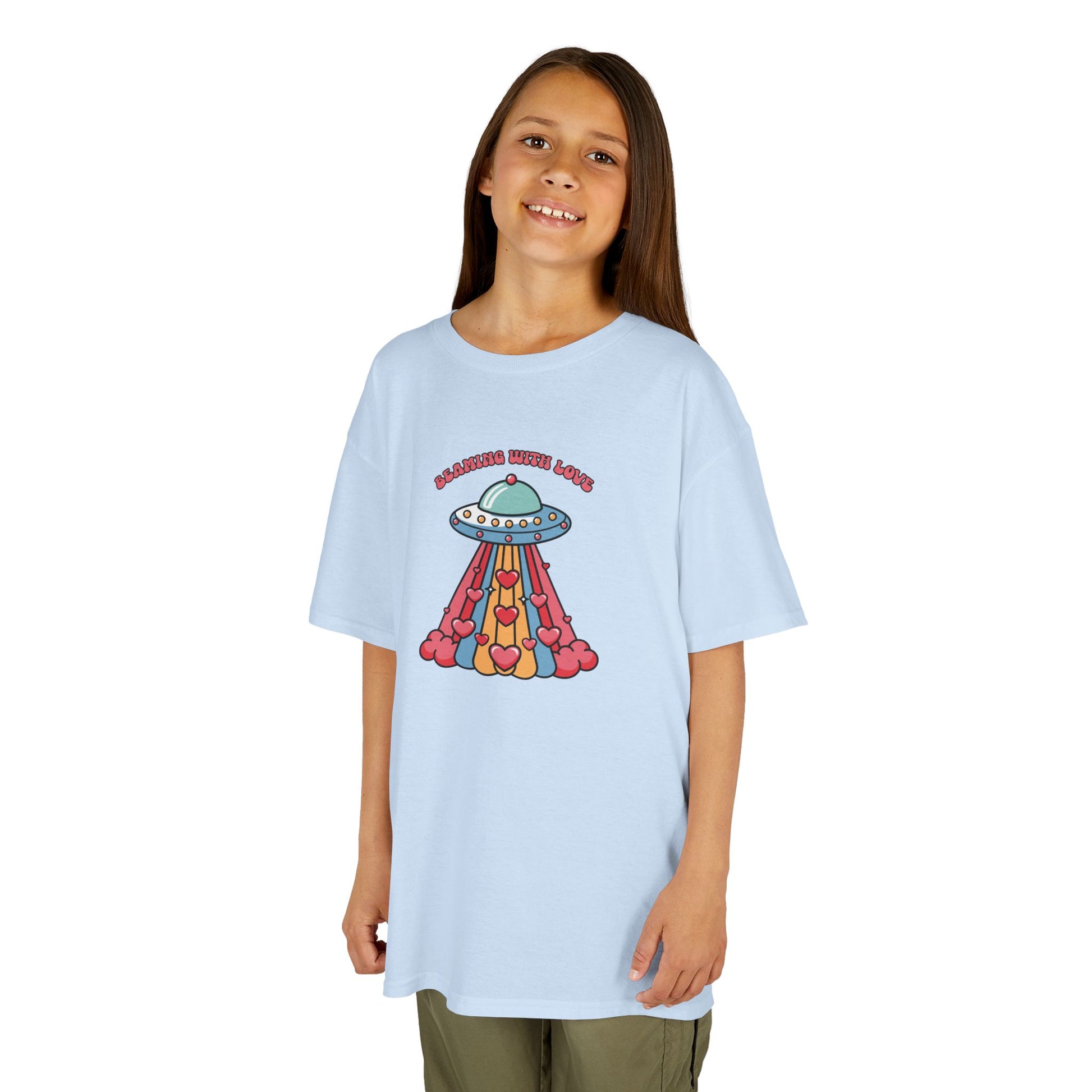 Girl wearing a light blue "Beaming With Love" kids T-shirt with a colorful UFO beaming down hearts. Part of the Vivid Divergence Sensory Friendly Kids Shirts Range. The perfect T-shirt for sensory-sensitive kids and comes with a Sensory Satisfaction Promise.