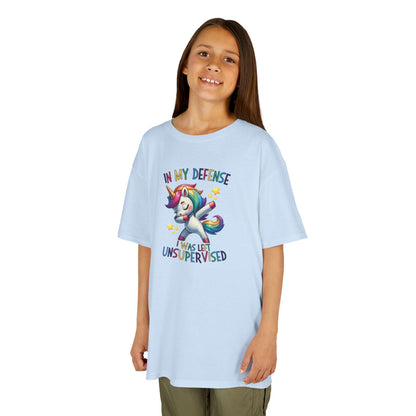 Girl wearing a light blue "In My Defense, I Was Left Unsupervised" unicorn kids T-shirt with a playful, colorful unicorn graphic. Part of the Vivid Divergence Sensory Friendly Kids Shirts Range. The perfect T-shirt for sensory-sensitive kids and comes with a Sensory Satisfaction Promise.