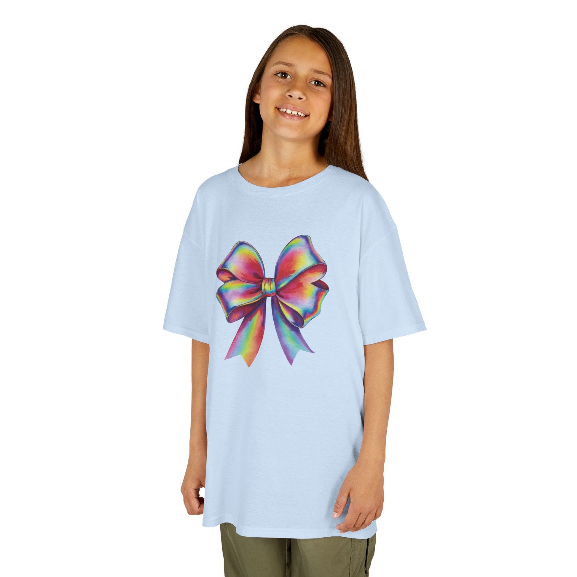 Girl wearing a light blue "Rainbow Holographic Bow" kids T-shirt with a colorful holographic bow graphic. Part of the Vivid Divergence Sensory Friendly Kids Shirts Range. The perfect T-shirt for sensory-sensitive kids and comes with a Sensory Satisfaction Promise.