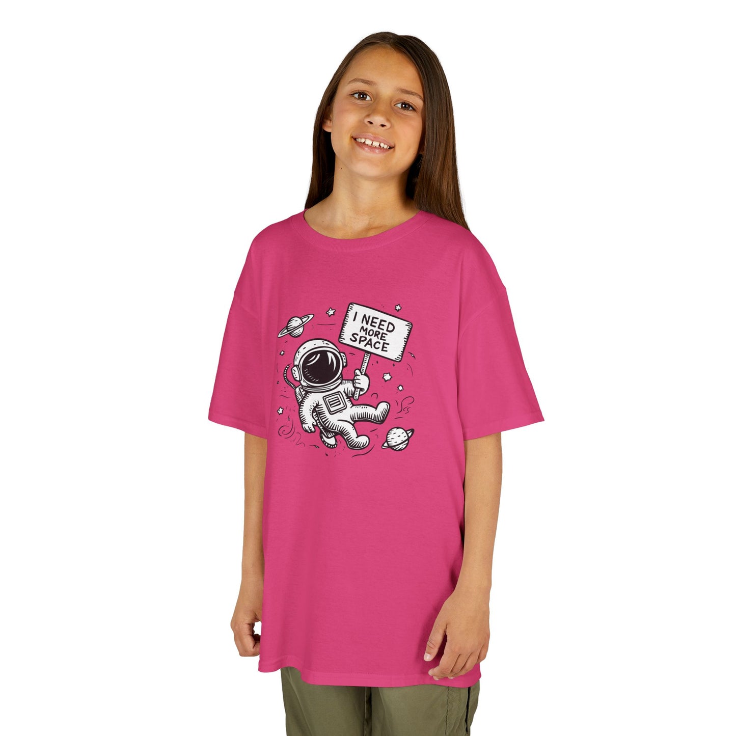 Girl wearing a pink "I Need More Space" astronaut kids T-shirt with a cartoon astronaut floating among space icons. Part of the Vivid Divergence Sensory Friendly Kids Shirts Range. The perfect T-shirt for sensory-sensitive kids and comes with a Sensory Satisfaction Promise.