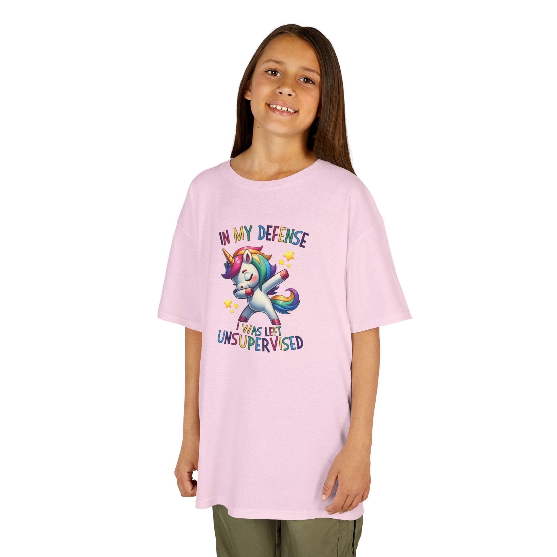 Girl wearing a pink "In My Defense, I Was Left Unsupervised" unicorn kids T-shirt with a playful, colorful unicorn graphic. Part of the Vivid Divergence Sensory Friendly Kids Shirts Range. The perfect T-shirt for sensory-sensitive kids and comes with a Sensory Satisfaction Promise.