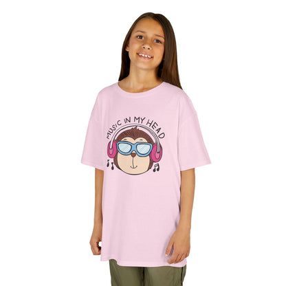 Girl wearing a pink "Music In My Head" monkey kids T-shirt with a cartoon monkey wearing headphones. Part of the Vivid Divergence Sensory Friendly Kids Shirts Range. The perfect T-shirt for sensory-sensitive kids and comes with a Sensory Satisfaction Promise.