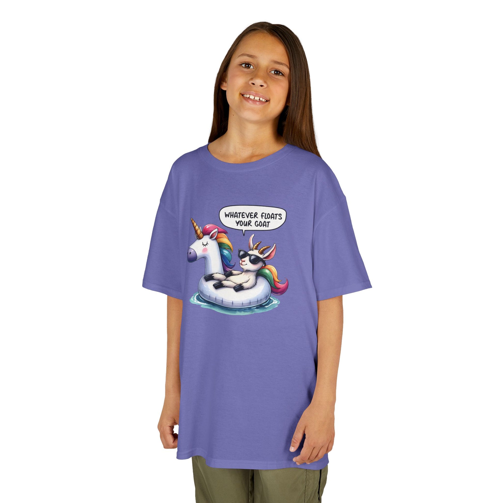 Girl wearing a purple "Whatever Floats Your Goat" kids T-shirt with a cartoon goat floating on a unicorn pool float. Part of the Vivid Divergence Sensory Friendly Kids Shirts Range. The perfect T-shirt for sensory-sensitive kids and comes with a Sensory Satisfaction Promise.