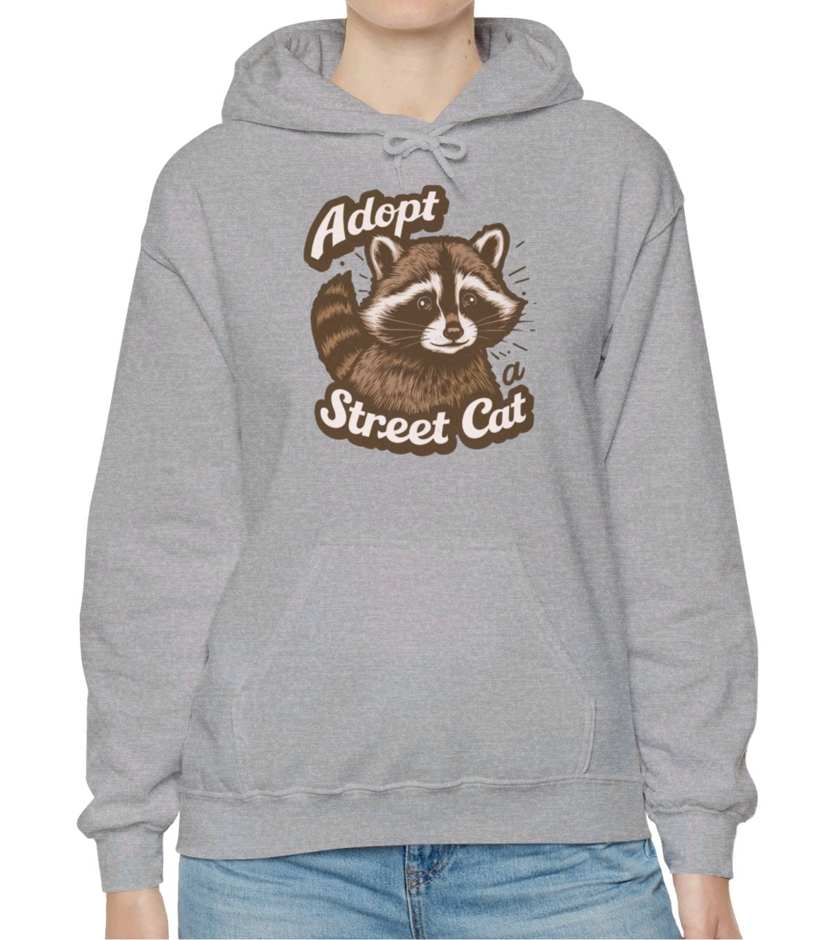 Model wearing a gray hoodie with the text "Adopt a Street Cat" and a cartoon illustration of a raccoon holding a cup. Part of the Vivid Divergence Sensory Friendly Unisex Hoodie Range.