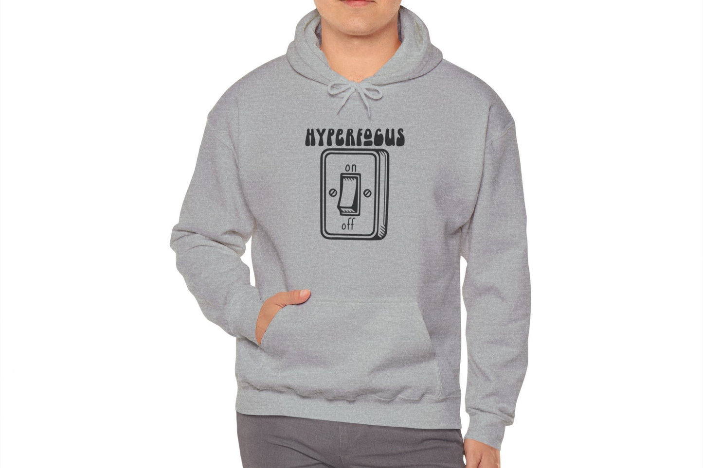 Model wearing a gray hoodie featuring the text "Hyperfocus" and an illustration of a toggle switch turned on. Part of the Vivid Divergence Sensory Friendly Unisex Hoodie Range.