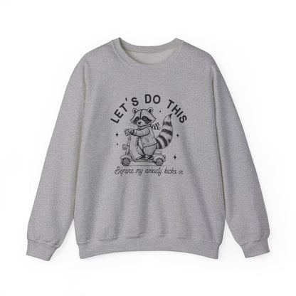 Front view of a gray sweatshirt featuring a cartoon raccoon riding a scooter with the text "Let's Do This Before My Anxiety Kicks In." Part of the Vivid Divergence Sensory Friendly Unisex Sweater Jumper Range.