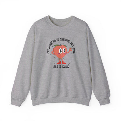Front view of a gray sweater jumper with the text "My anxiety is chronic but this ass is iconic" and a cartoon peach illustration. Part of the Vivid Divergence Sensory Friendly Unisex Sweater Jumper Range.