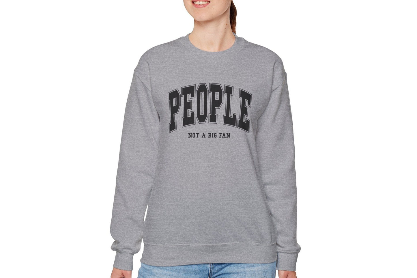 Model wearing a gray sweater jumper with the text "People. Not a Big Fan" in bold white lettering. Part of the Vivid Divergence Sensory Friendly Unisex Sweater Jumper Range.