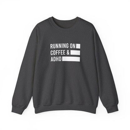 Front view of a gray sweater jumper with the text "Running on Coffee & ADHD" in bold white lettering and a battery graphic. Part of the Vivid Divergence Sensory Friendly Unisex Sweater Jumper Range.