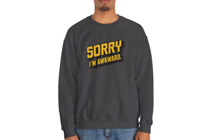 Model wearing a gray sweater jumper with the text "Sorry, I'm Awkward." in bold yellow lettering. Part of the Vivid Divergence Sensory Friendly Unisex Sweater Jumper Range.