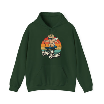 Front view of a forest green hoodie featuring a retro-style sunset background with an illustration of Cupid riding a skateboard and the text "Cupid Stunt." Part of the Vivid Divergence Sensory Friendly Unisex Hoodie Range.