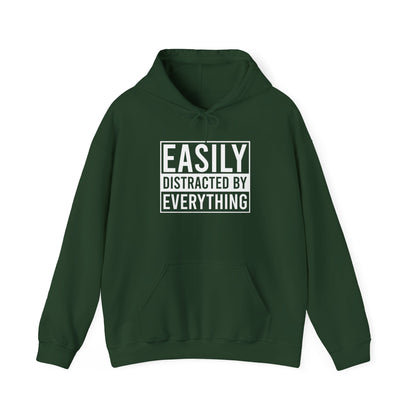 Front view of a green hoodie with the text "Easily Distracted by Everything" in bold white lettering. Part of the Vivid Divergence Sensory Friendly Unisex Hoodie Range.