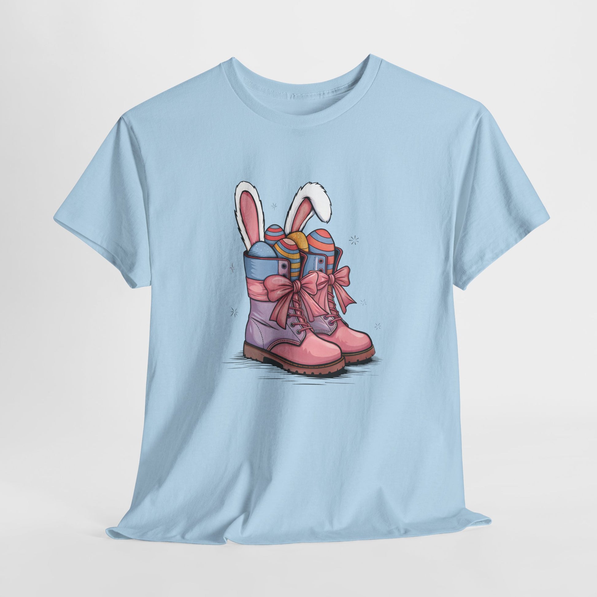 Light Blue T-shirt hanging, displaying an Easter cowgirl boots design with bunny ears and eggs, a cute springtime look. Hop into the season in style and shop Easter shirts online today!