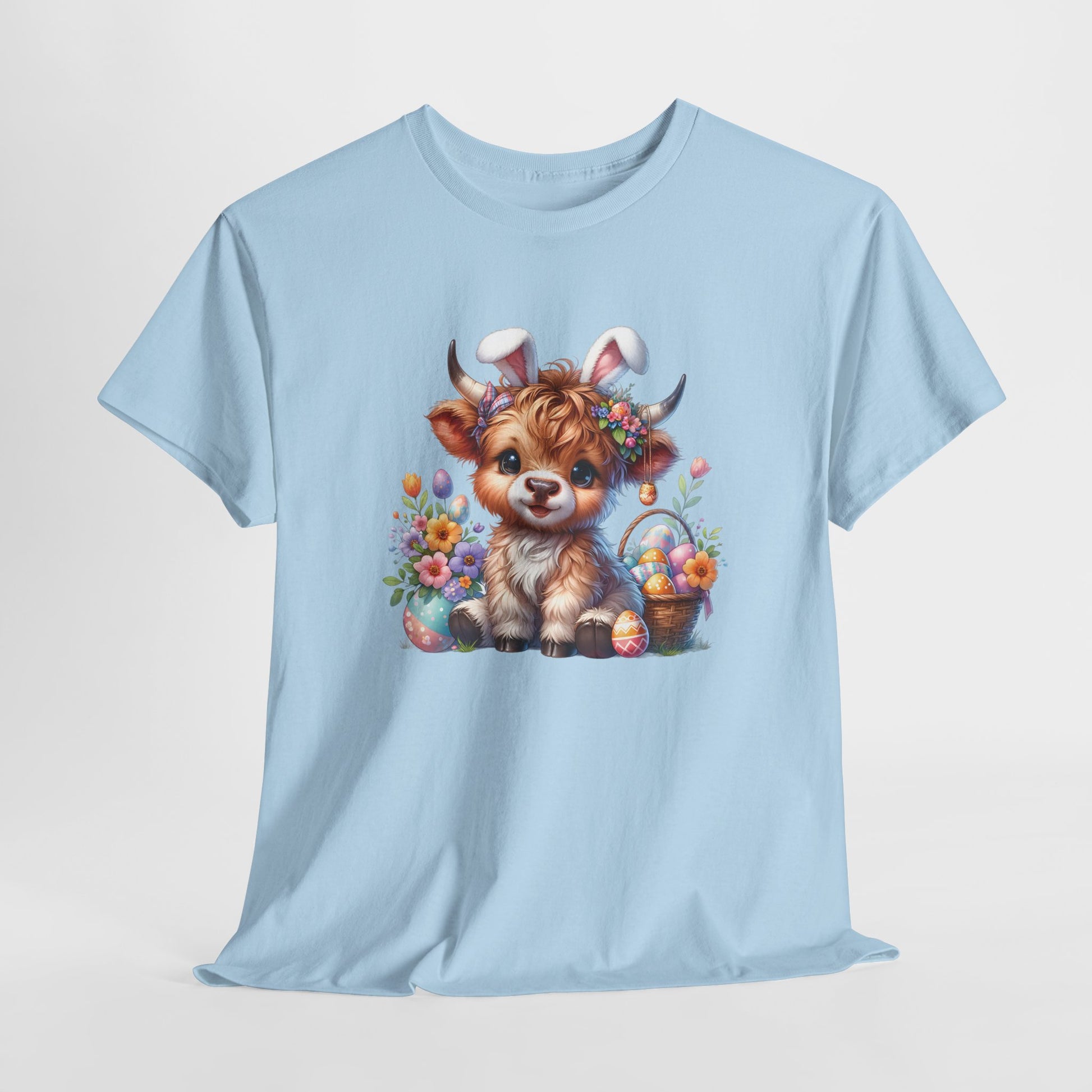 Light Blue T-shirt hanging, decorated with a festive Highland cow surrounded by spring florals and Easter eggs, ideal for Easter celebrations. Hop into the season in style and shop Easter shirts online today!