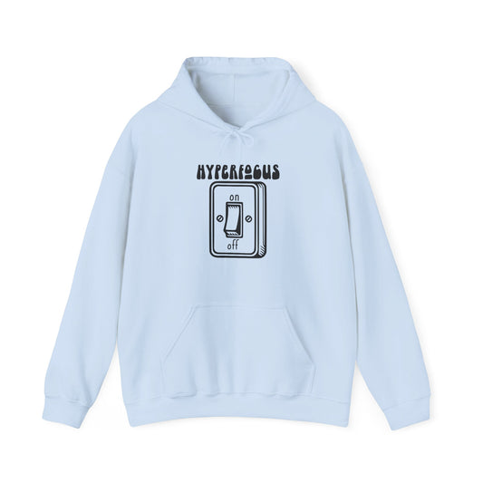 Front view of a light blue hoodie featuring the text "Hyperfocus" and an illustration of a toggle switch turned on. Part of the Vivid Divergence Sensory Friendly Unisex Hoodie Range.