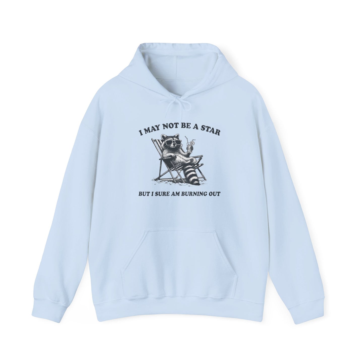 Front view of a light blue hoodie featuring a raccoon sitting in a trash can with the text "I May Not Be A Star, But I Sure Am Burning Out." Part of the Vivid Divergence Sensory Friendly Unisex Hoodie Range.
