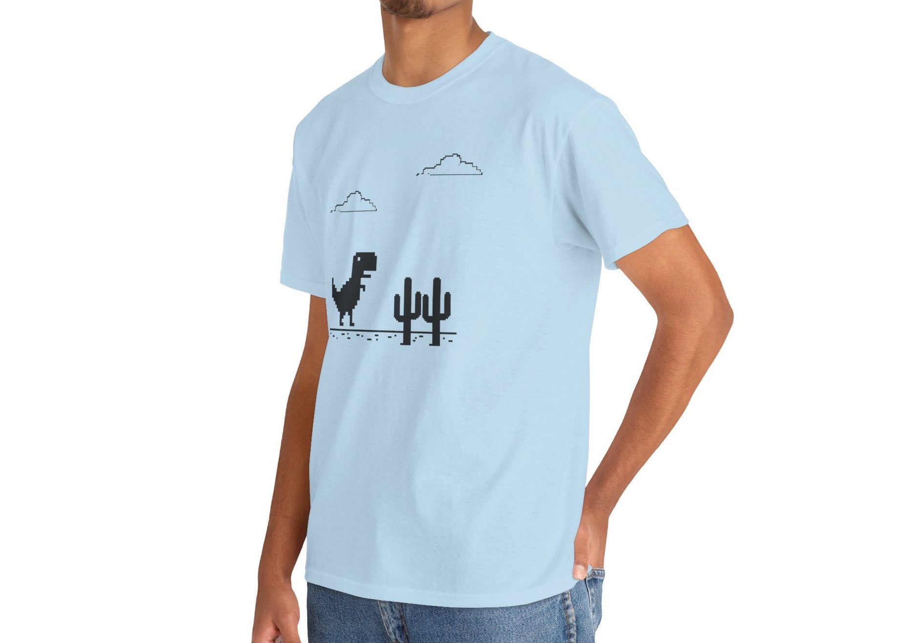 Front view of a light blue T-shirt featuring a minimalist pixel-style T-Rex Runner Dinosaur Game design with a T-Rex, cacti, and clouds. Part of the Vivid Divergence Sensory Friendly Unisex Tees Range.