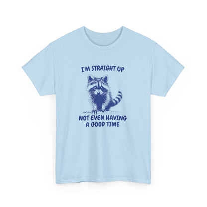 Front view of a light blue T-shirt featuring a distressed raccoon graphic with the text "I'm Straight Up Not Even Having a Good Time." Part of the Vivid Divergence Sensory Friendly Unisex Tees Range.
