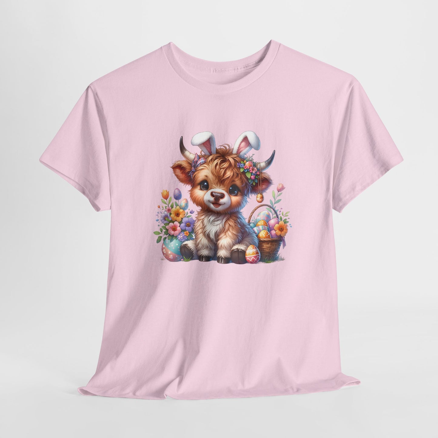 Light Pink T-shirt hanging, showcasing a fluffy Highland cow with Easter decorations, a cute and rustic holiday outfit. Hop into the season in style and shop Easter shirts online today!