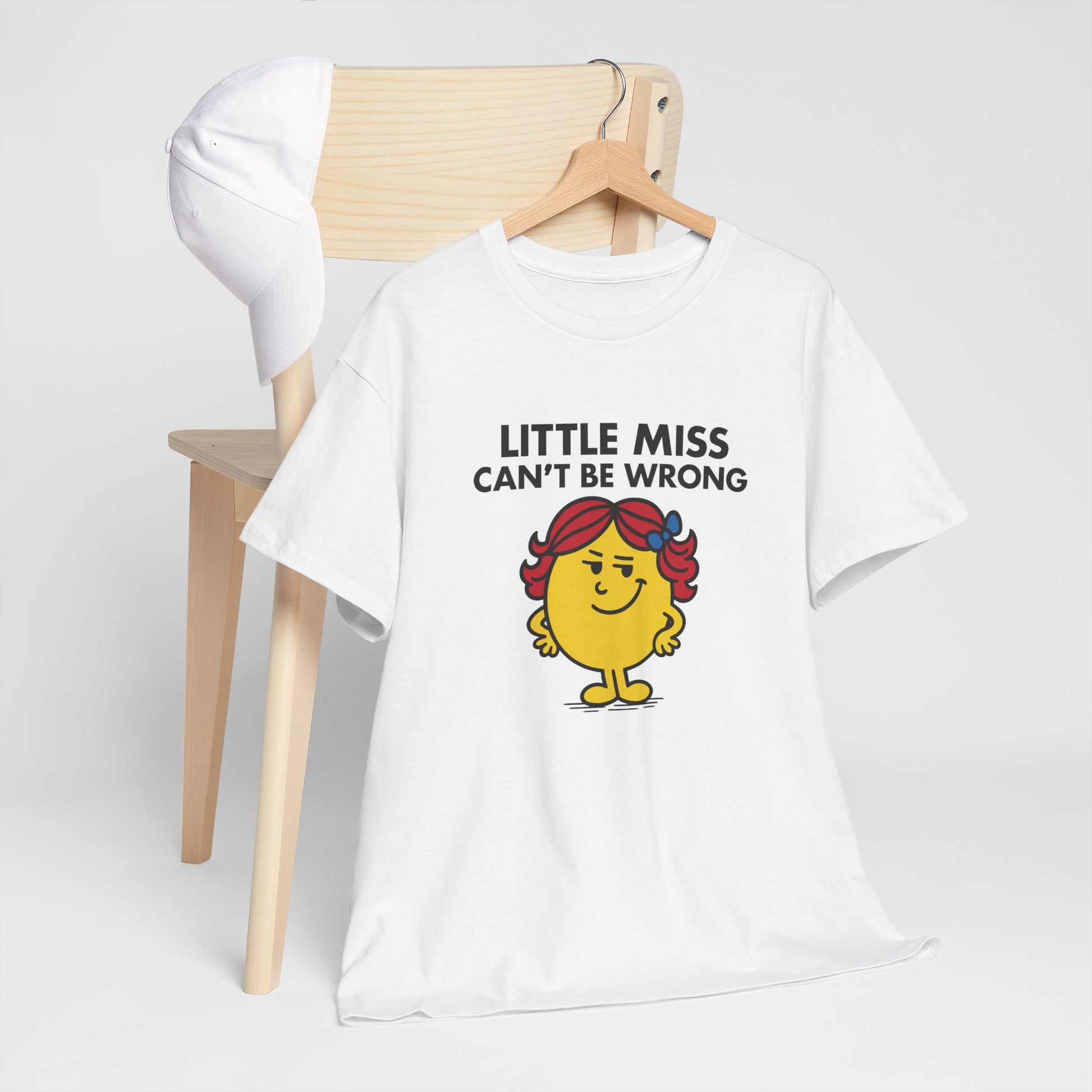 Little Miss Can’t Be Wrong T-shirt draped over a chair in a cozy setting. Part of the Little Miss Meme Character Collection. A Vivid Divergence Sensory Friendly Unisex Tee.