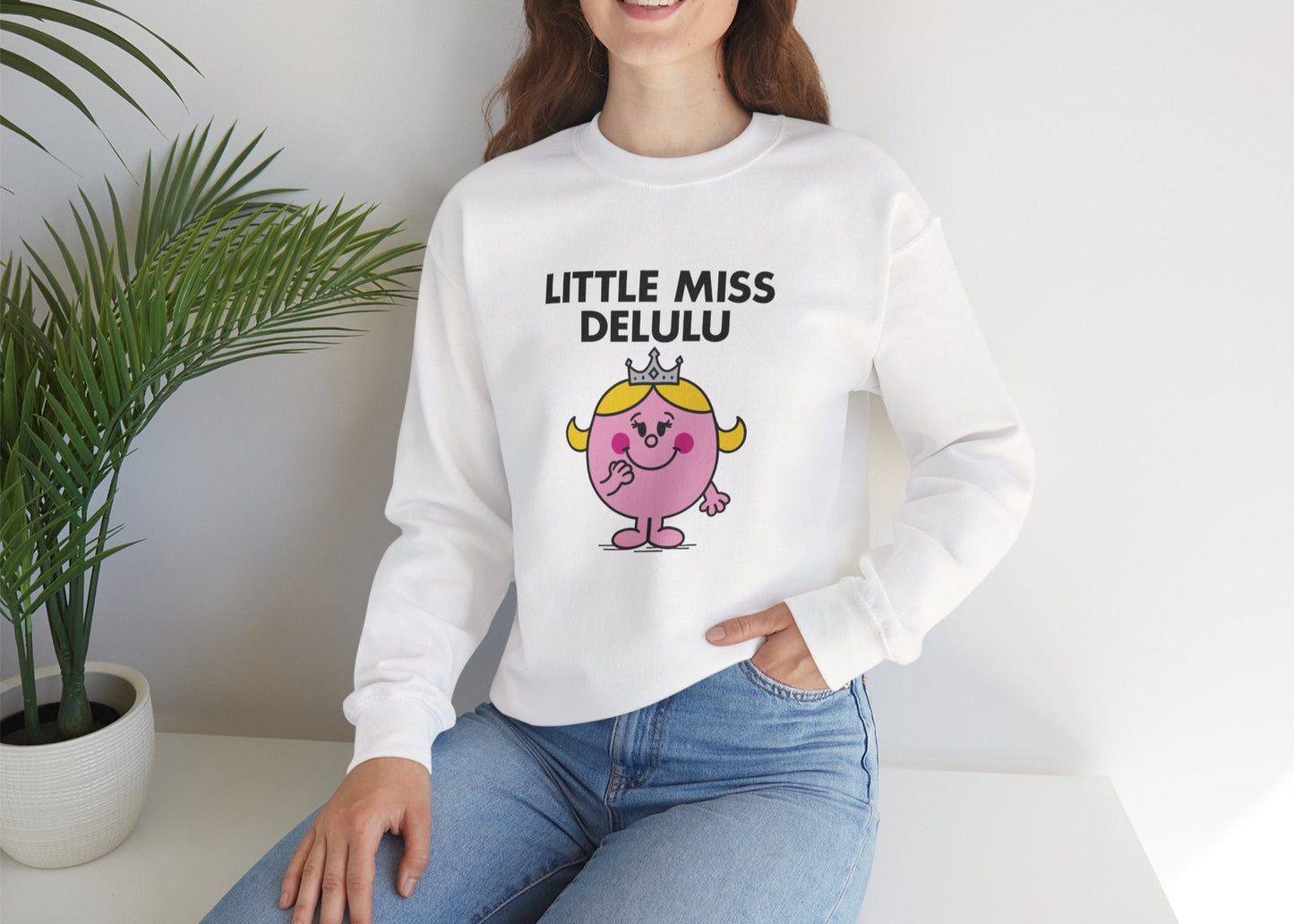 Person wearing the Little Miss Delulu sweatshirt while seated casually. Part of the Little Miss Meme Character Collection. A Vivid Divergence Sensory Friendly Sweater Jumper.
