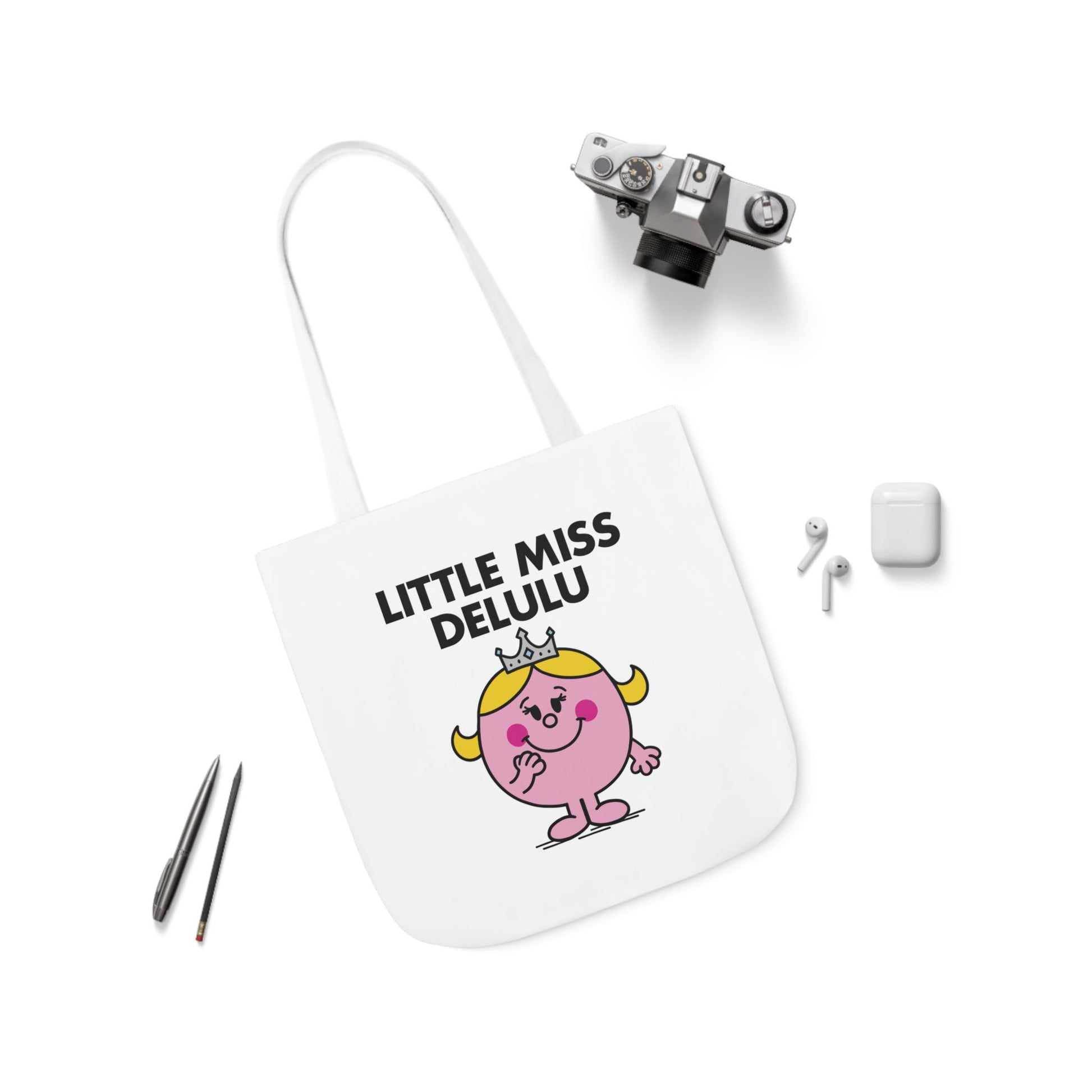 Flat lay of tote bag featuring Little Miss Delulu, surrounded by cute desk items — perfect for journaling fake conversations. Part of the Vivid Divergence Little Miss Meme Collection!
