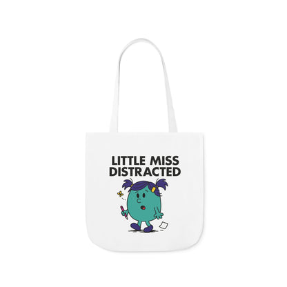 Front view of white canvas tote bag featuring teal character with wide eyes, raised hand, and stars swirling above her head. Text reads "Little Miss Distracted." She meant to focus, then got lost in a daydream. Part of the Vivid Divergence Little Miss Meme Collection!
