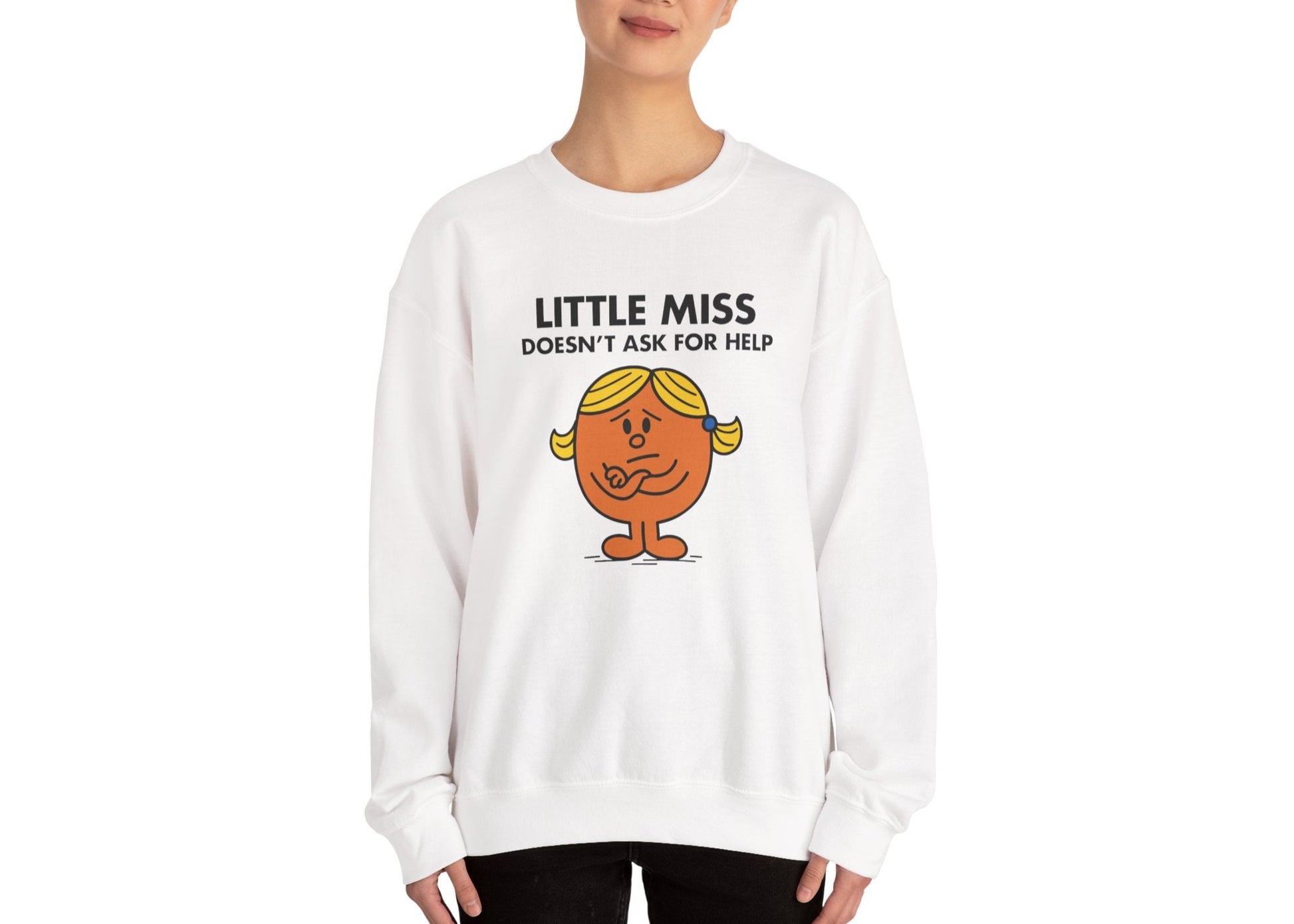 Person wearing the Little Miss Doesn’t Ask For Help sweatshirt in a relaxed pose. Part of the Little Miss Meme Character Collection. A Vivid Divergence Sensory Friendly Sweater Jumper.
