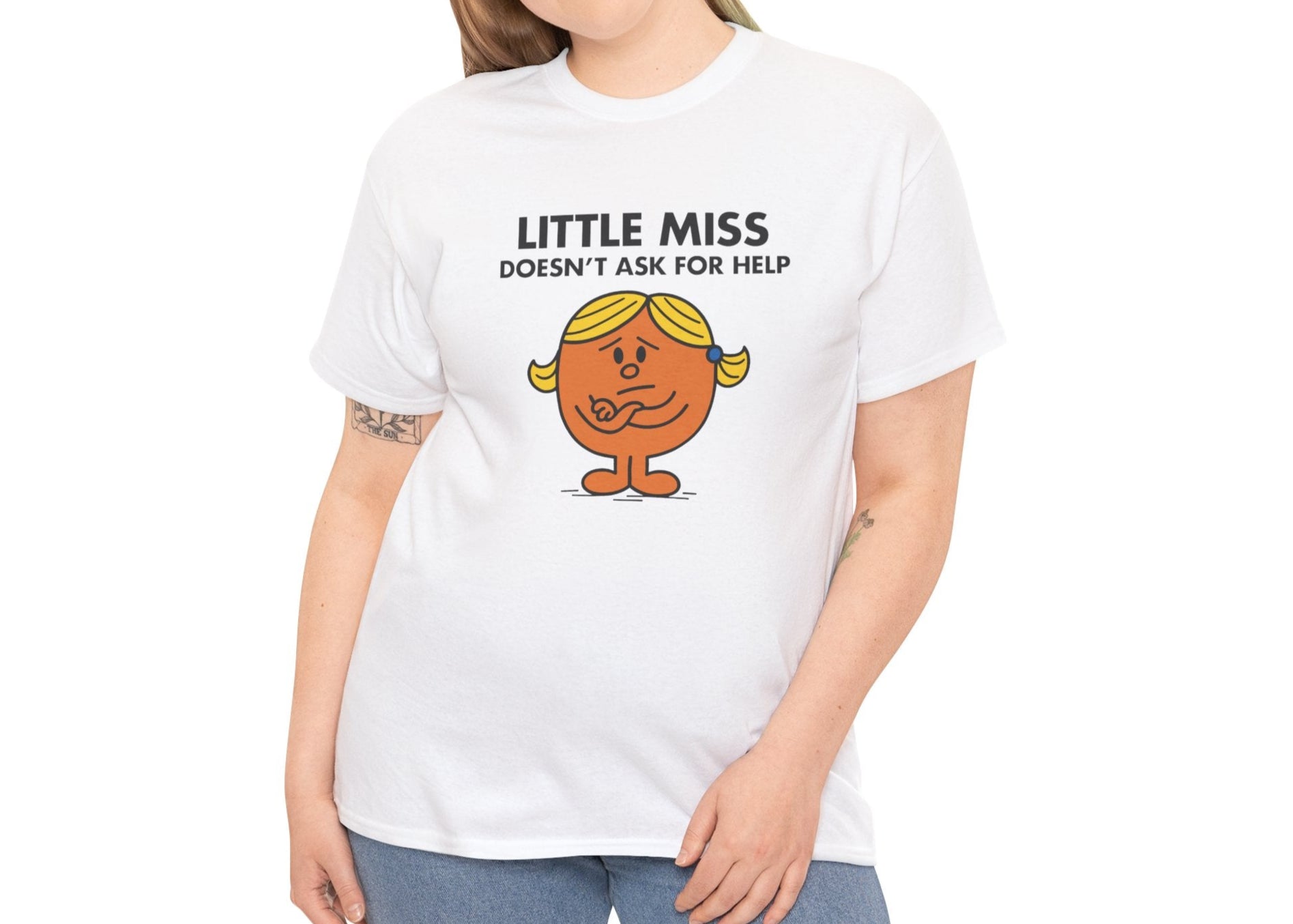 Person wearing the Little Miss Doesn’t Ask For Help T-shirt with light jeans. Part of the Little Miss Meme Character Collection. A Vivid Divergence Sensory Friendly Unisex Tee.

