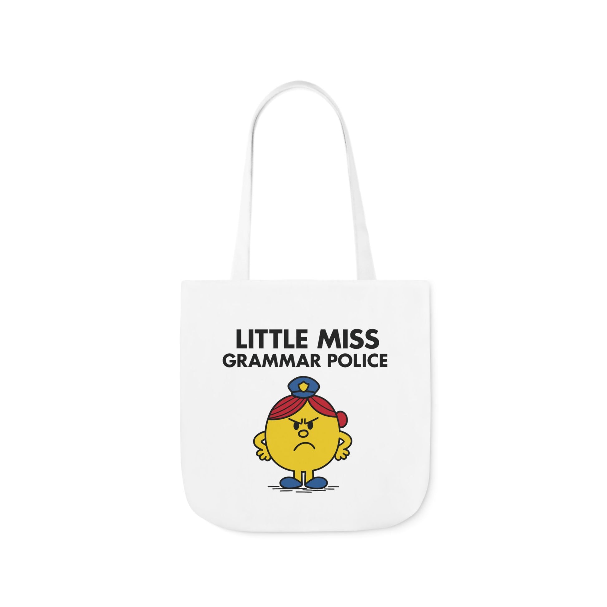 Front view of white canvas tote bag featuring yellow character with stern eyes, arms crossed, and a red cap under the text "Little Miss Grammar Police." She’s judging your misplaced apostrophes. Part of the Vivid Divergence Little Miss Meme Collection!
