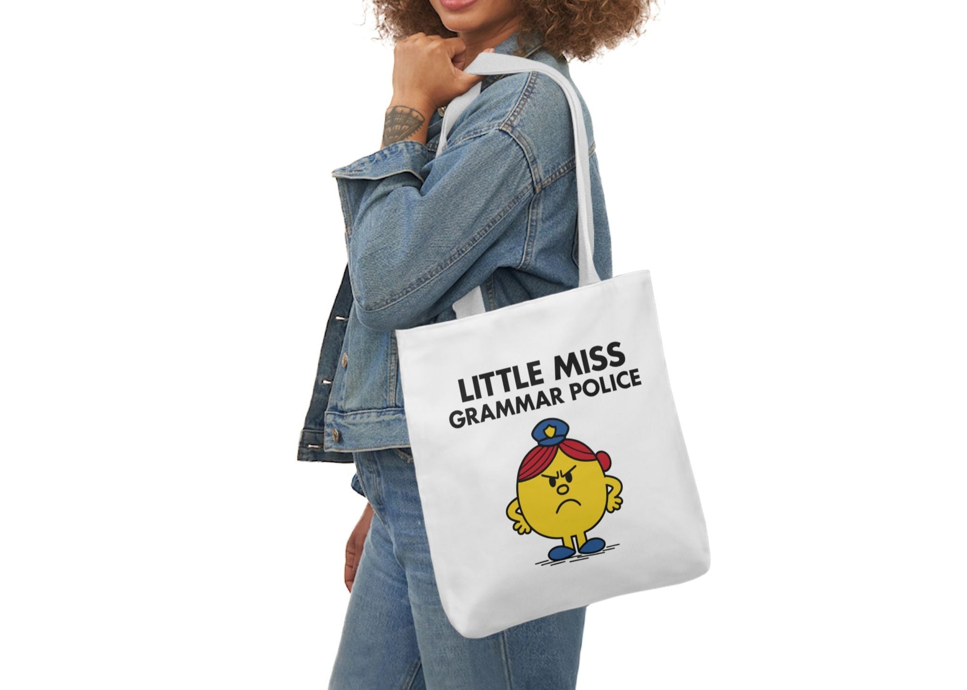 Woman in denim modeling the Little Miss Grammar Police tote over her shoulder. She corrects people in real life and online. Part of the Vivid Divergence Little Miss Meme Collection!
