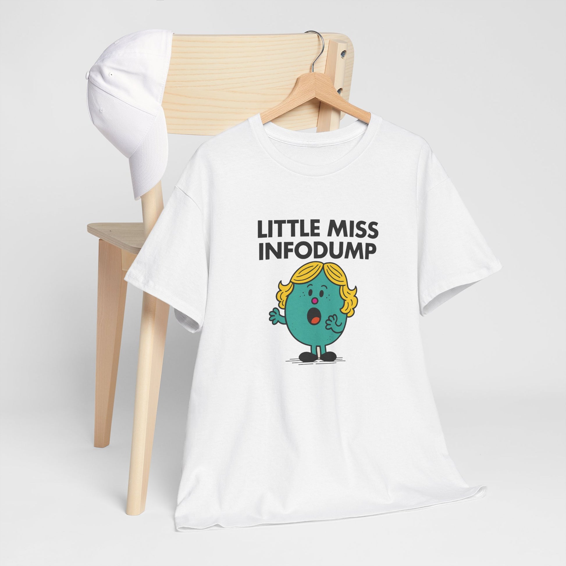 Little Miss Infodump T-shirt draped over a wooden chair in a simple setting. Part of the Little Miss Meme Character Collection. A Vivid Divergence Sensory Friendly Unisex Tee.
