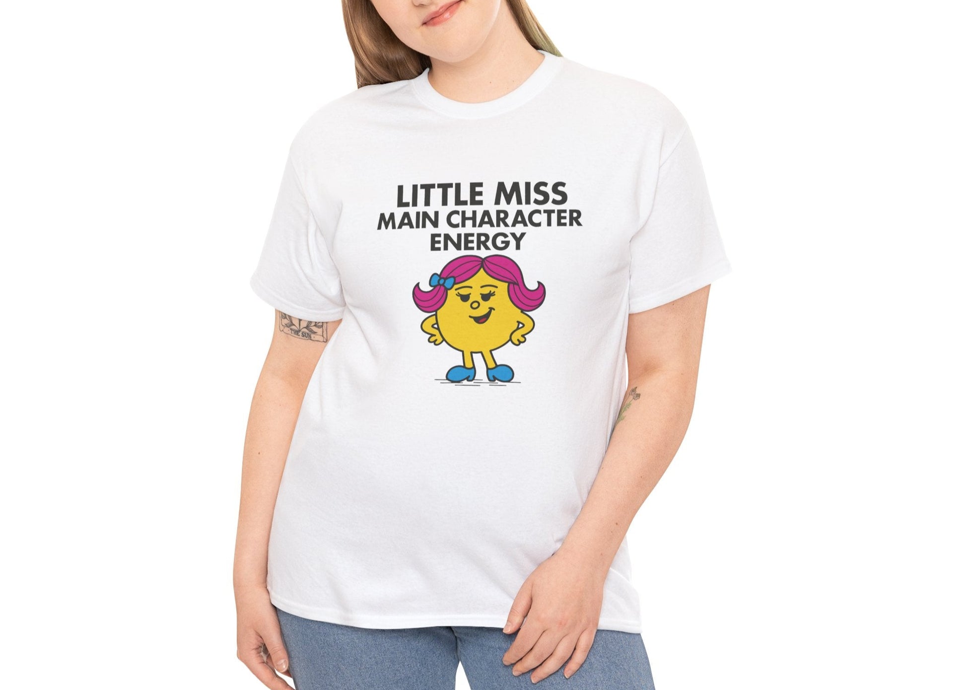 Person wearing the Little Miss Main Character Energy T-shirt with light-wash jeans. Part of the Little Miss Meme Character Collection. A Vivid Divergence Sensory Friendly Unisex Tee.
