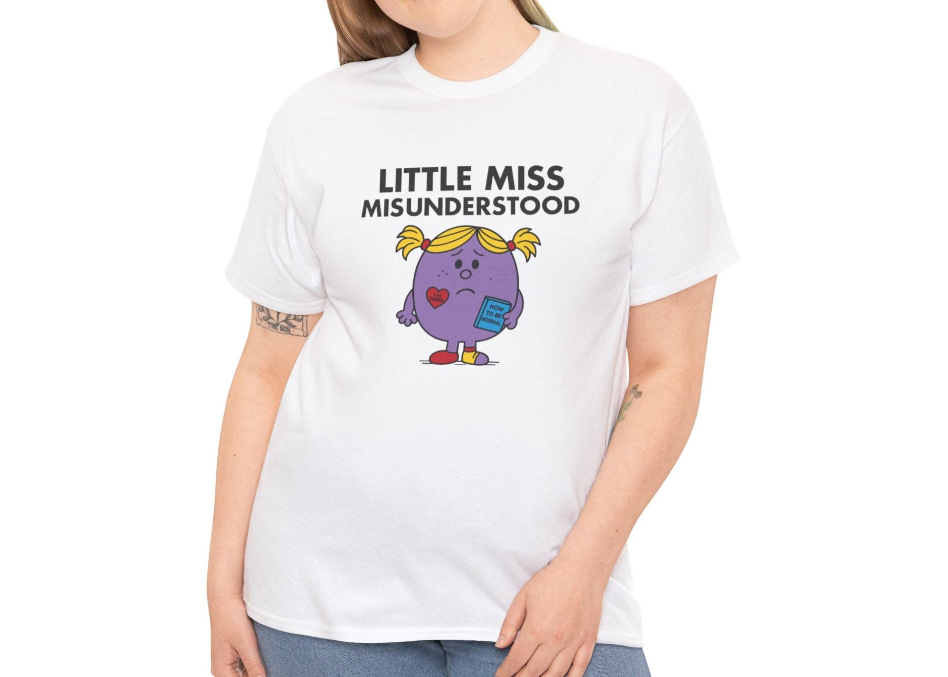 Person wearing the Little Miss Misunderstood T-shirt styled casually with jeans. Part of the Little Miss Meme Character Collection. A Vivid Divergence Sensory Friendly Unisex Tee.
