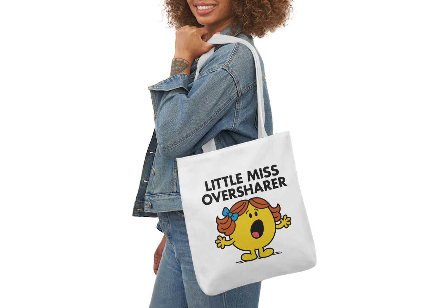 Woman in denim modeling the Little Miss Oversharer tote bag over her shoulder. She’s halfway through a story with way too much detail. Part of the Vivid Divergence Little Miss Meme Collection!
