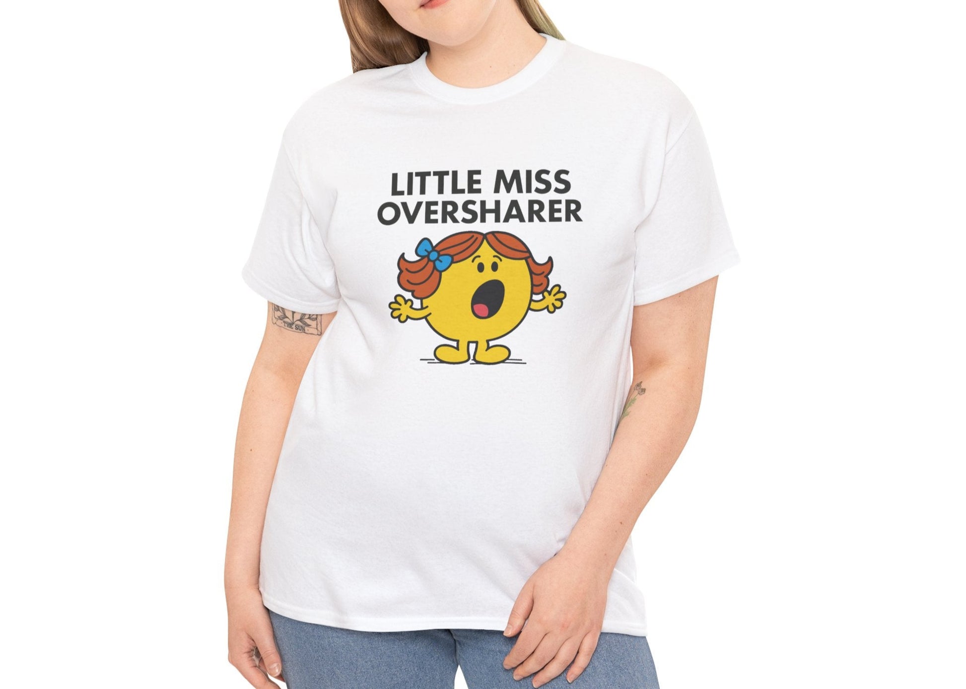 Person wearing the Little Miss Oversharer T-shirt with blue jeans. Part of the Little Miss Meme Character Collection. A Vivid Divergence Sensory Friendly Unisex Tee.
