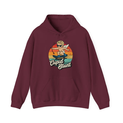 Front view of a maroon hoodie featuring a retro-style sunset background with an illustration of Cupid riding a skateboard and the text "Cupid Stunt." Part of the Vivid Divergence Sensory Friendly Unisex Hoodie Range.
