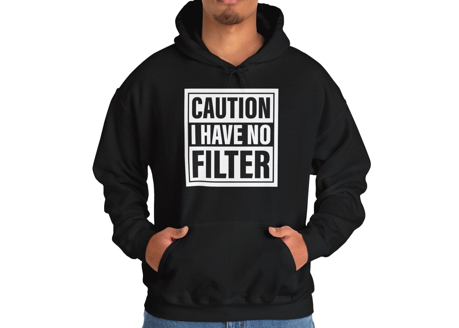 Model wearing a black hoodie with bold white text inside a rectangular border that reads "Caution: I Have No Filter," standing with hands in pockets. Part of the Vivid Divergence Sensory Friendly Unisex Hoodie Range.