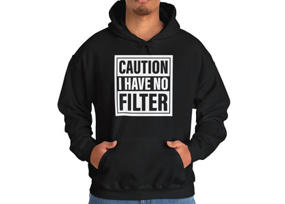 Model wearing a black hoodie with bold white text inside a rectangular border that reads "Caution: I Have No Filter," standing with hands in pockets. Part of the Vivid Divergence Sensory Friendly Unisex Hoodie Range.