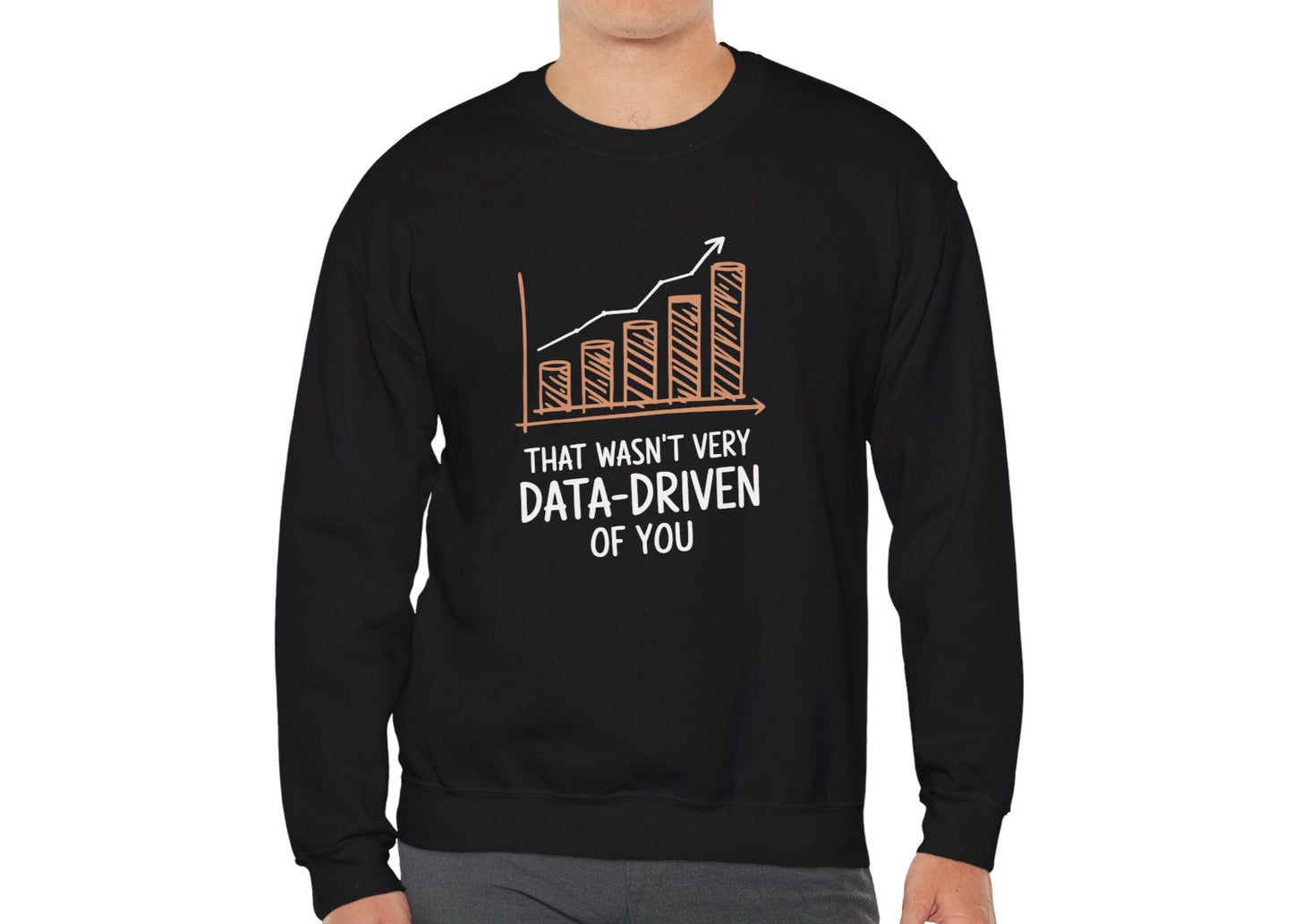 Model wearing a black sweatshirt with a rising bar graph illustration and the text "That Wasn't Very Data-Driven of You," standing with hands at sides. Part of the Vivid Divergence Sensory Friendly Unisex Sweater Jumper Range.