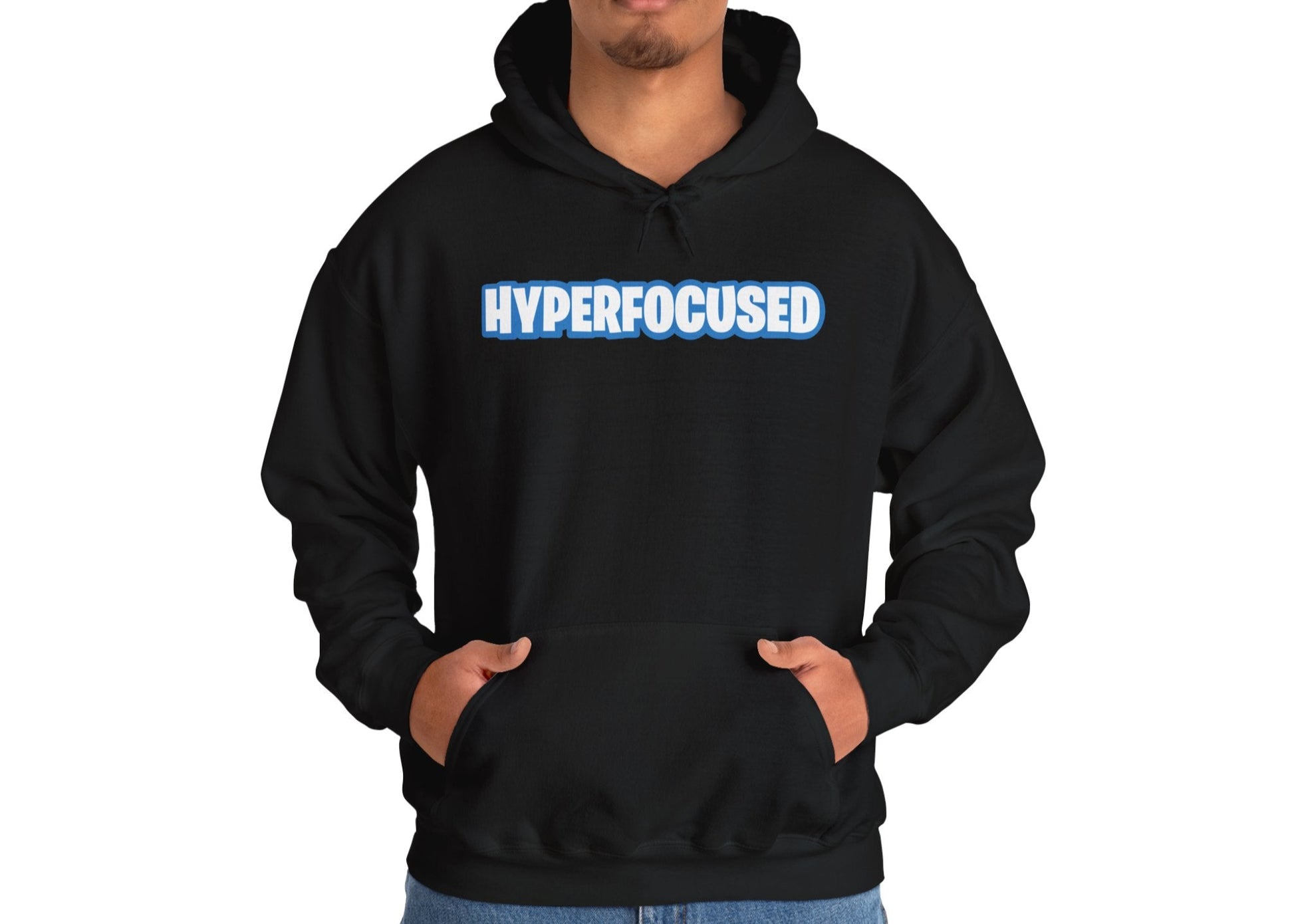 Model wearing a black hoodie with the word "HYPERFOCUSED" in a bold, blue Fortnite-style font, standing with hands in pockets. Part of the Vivid Divergence Sensory Friendly Unisex Hoodie Range.