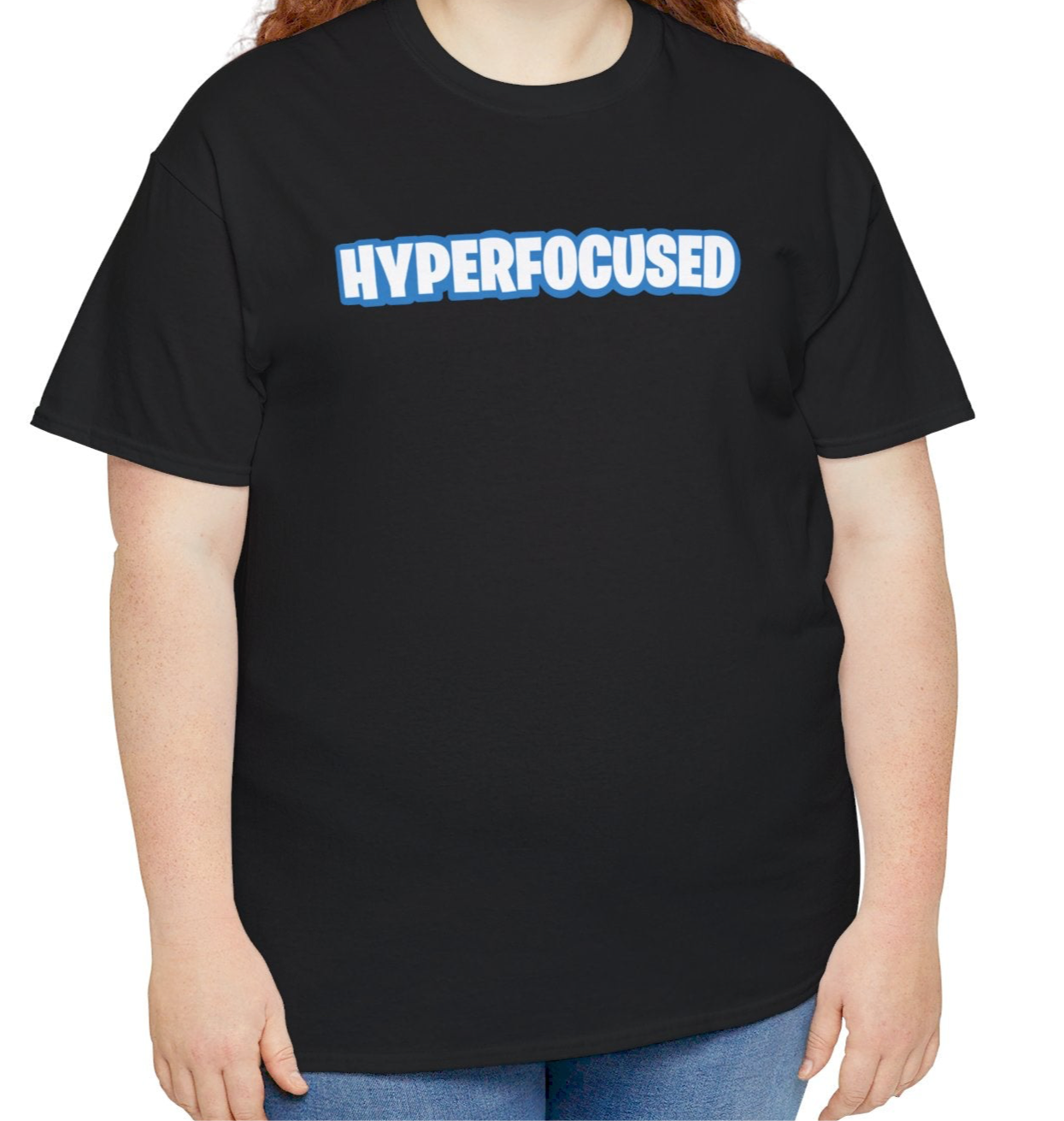A person wearing a black T-shirt with the text "Hyperfocused" in a Fortnite-style design. Part of the Vivid Divergence Sensory Friendly Unisex Tees Range.