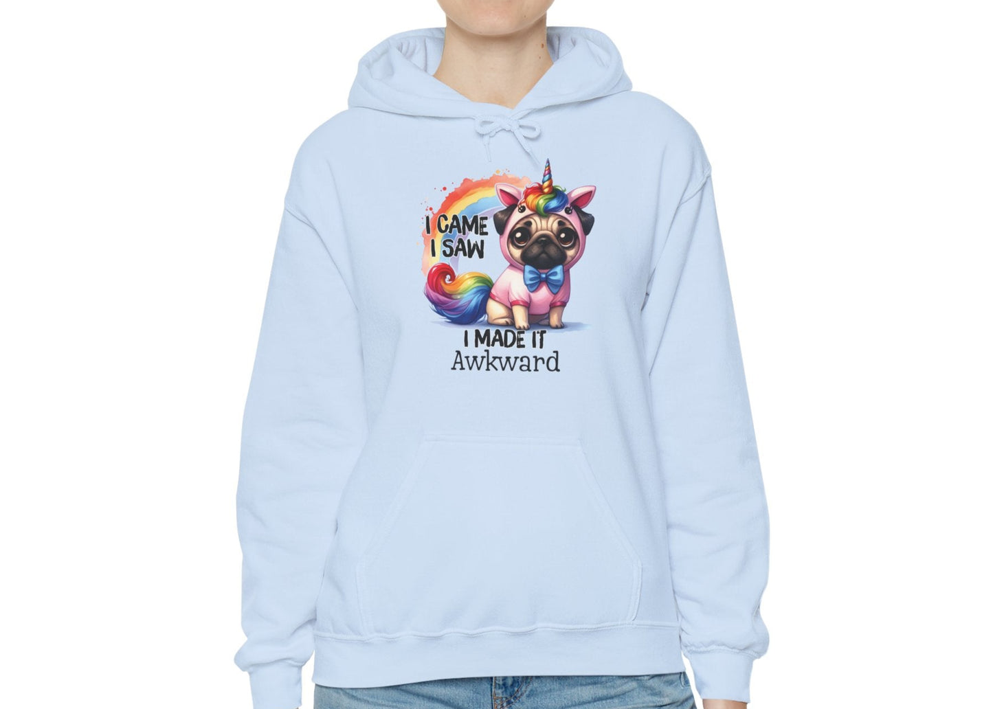 Model wearing a light blue hoodie with a colorful unicorn pug and the text "I Came, I Saw, I Made It Awkward," standing with hands at sides. Part of the Vivid Divergence Sensory Friendly Unisex Hoodie Range.